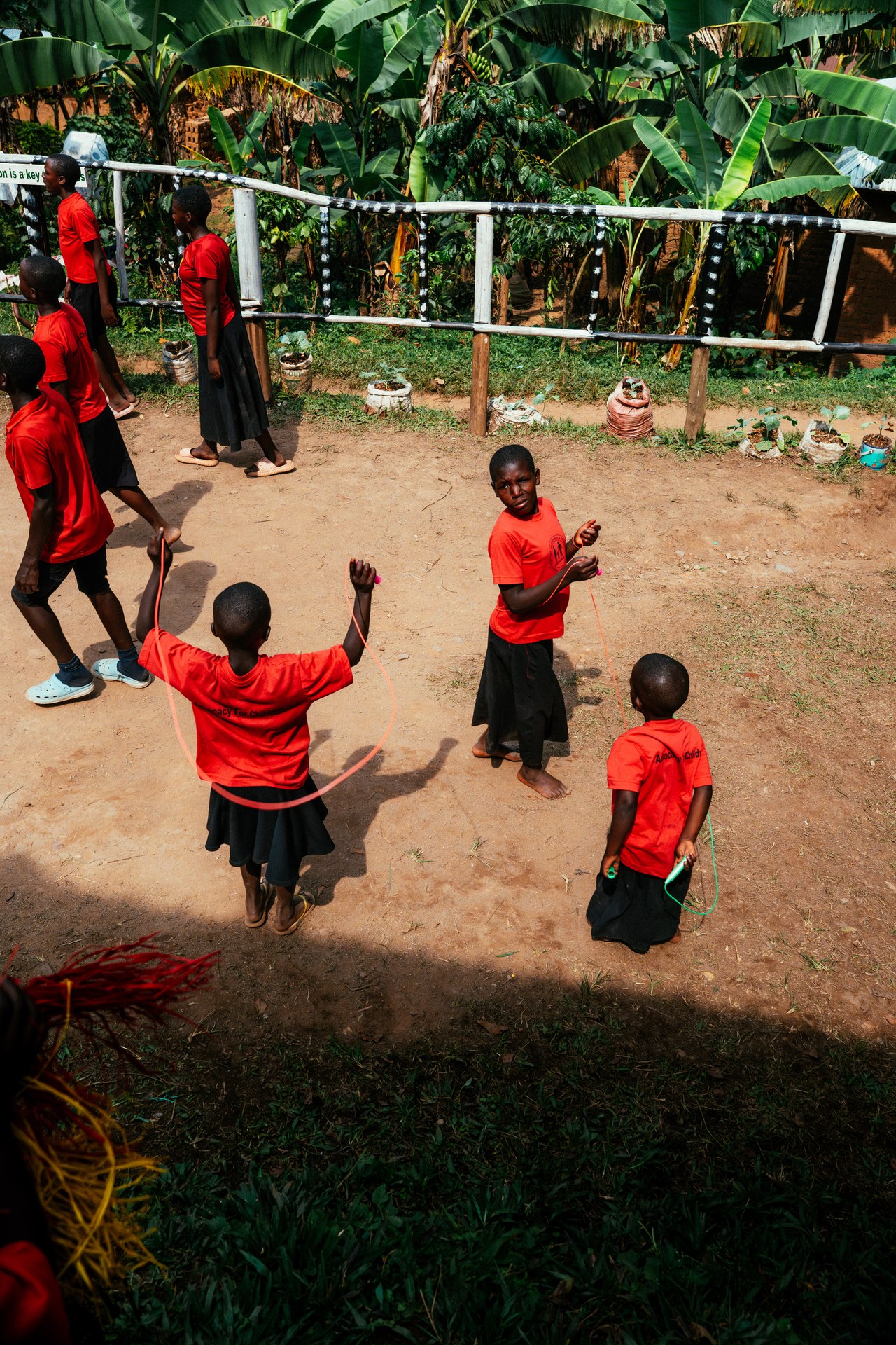 Kinder spielen Seilspringen auf dem Schulhof in Uganda