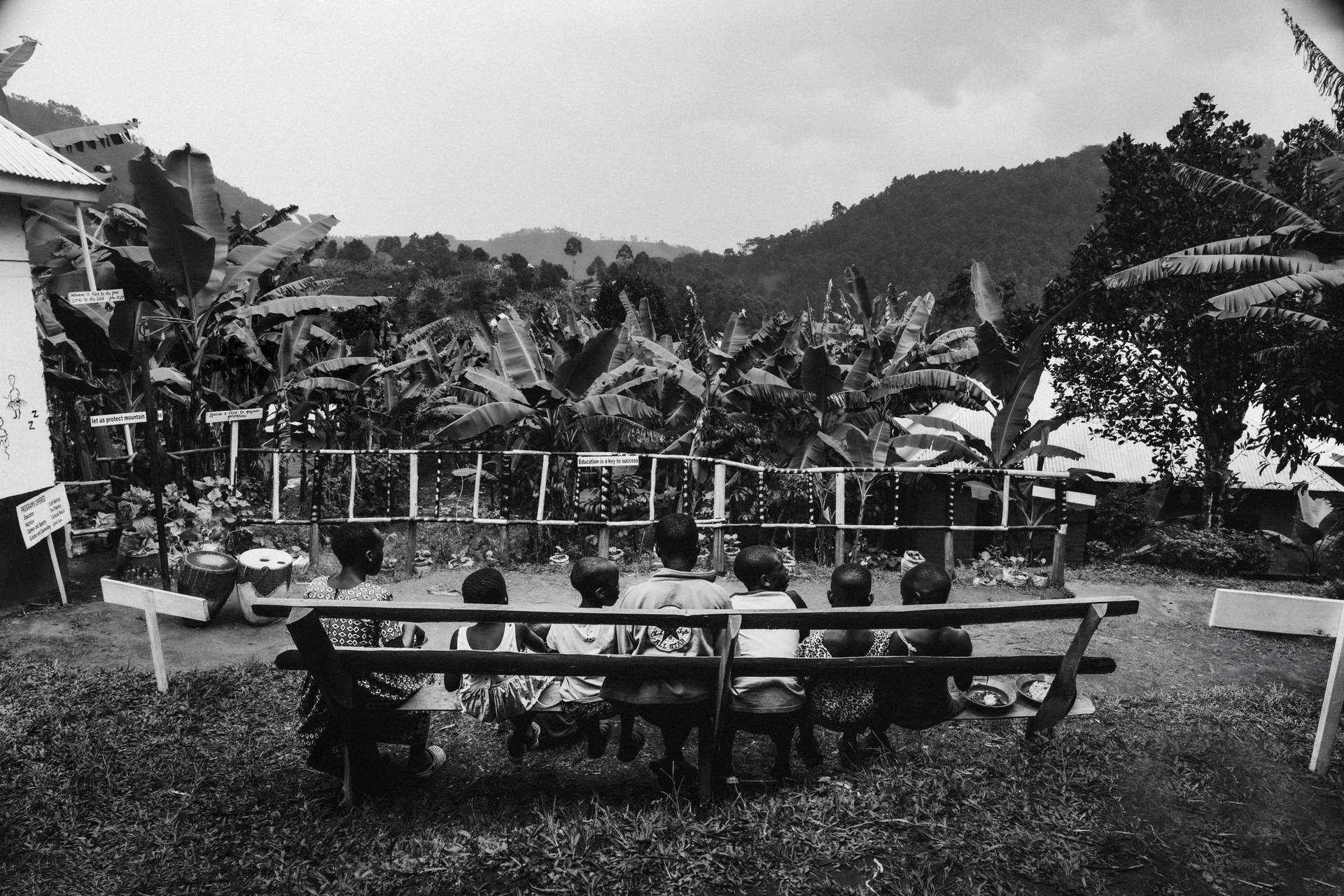 Community on a bench gazing at the Ugandan landscape