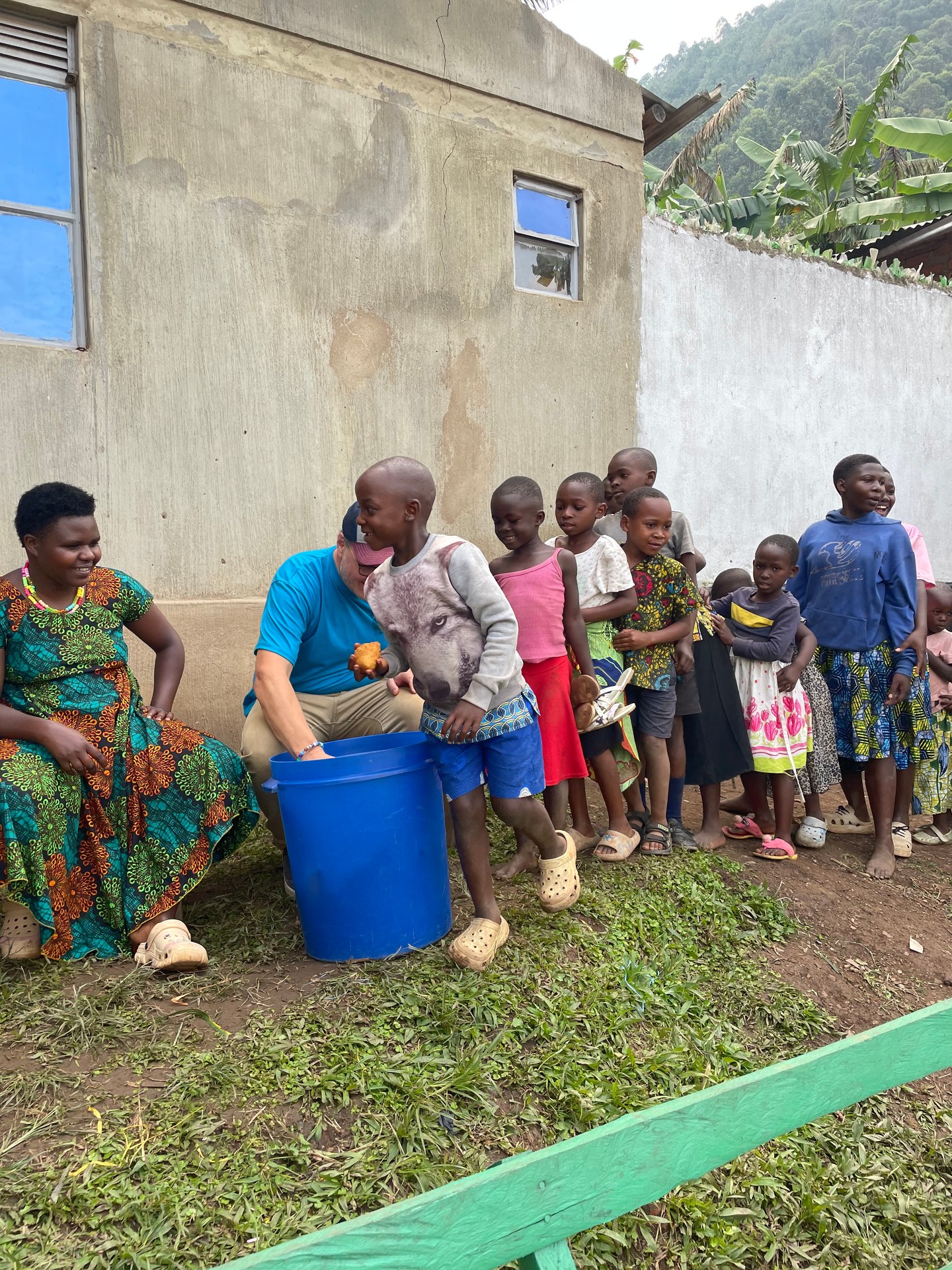 Children gathered around a bucket at Buhoma orphanage