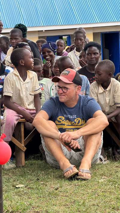 Mark sitzt bei Kindern zur Schulöffnung in Lwakhakha