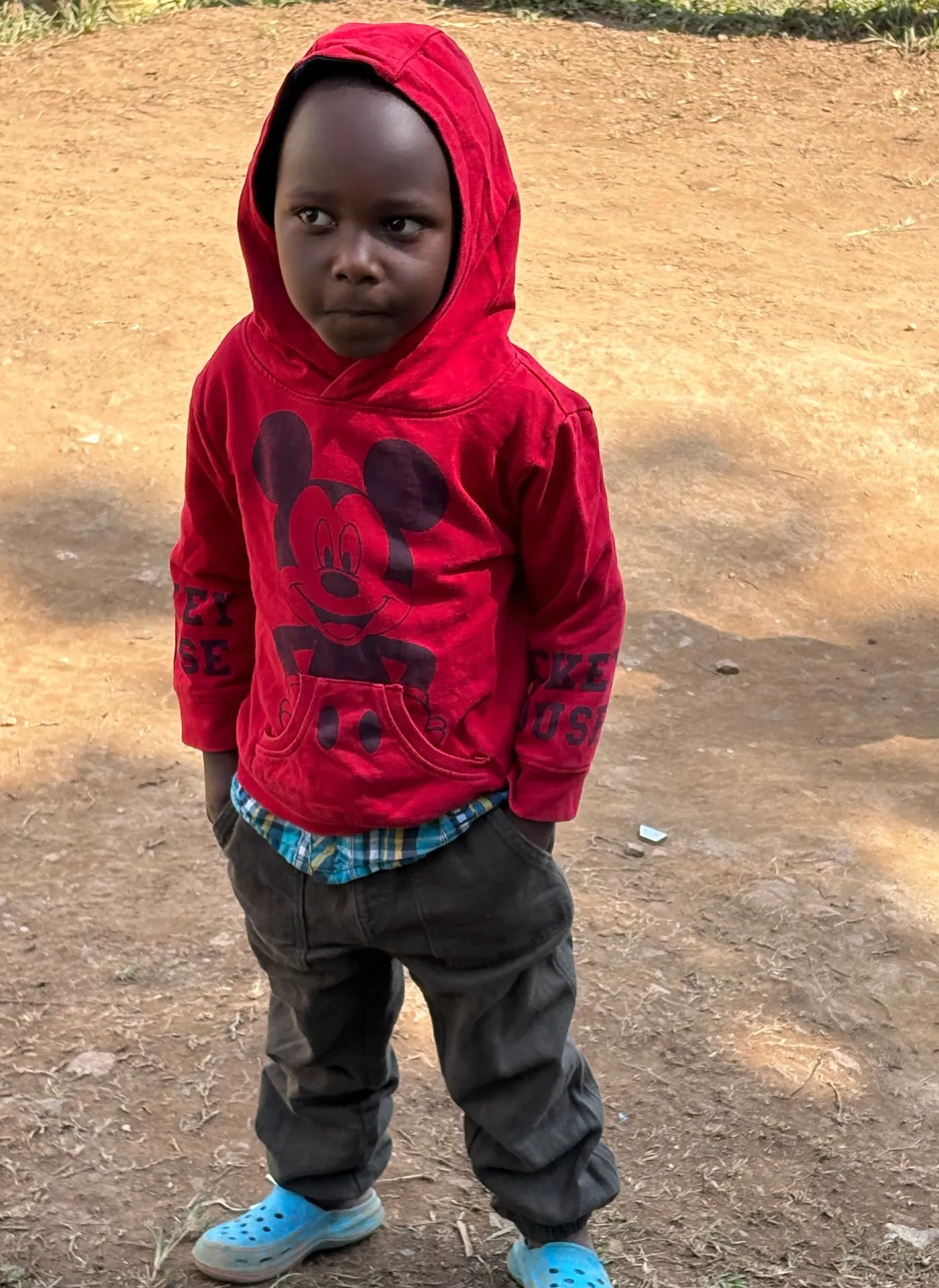 Young boy in a red hoodie in Buhoma village, Uganda — the next generation growing up alongside tourism