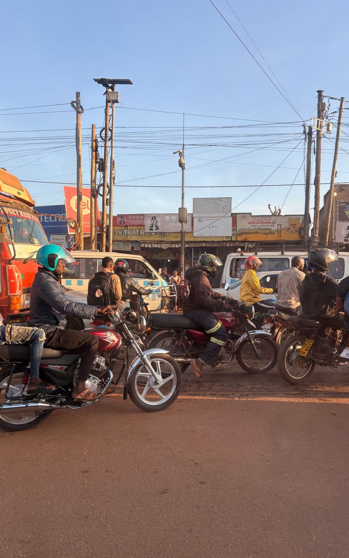 Boda-boda motorcycle taxis in Kampala traffic — photographed May 2026, GPS: 0.2918, 32.4996
