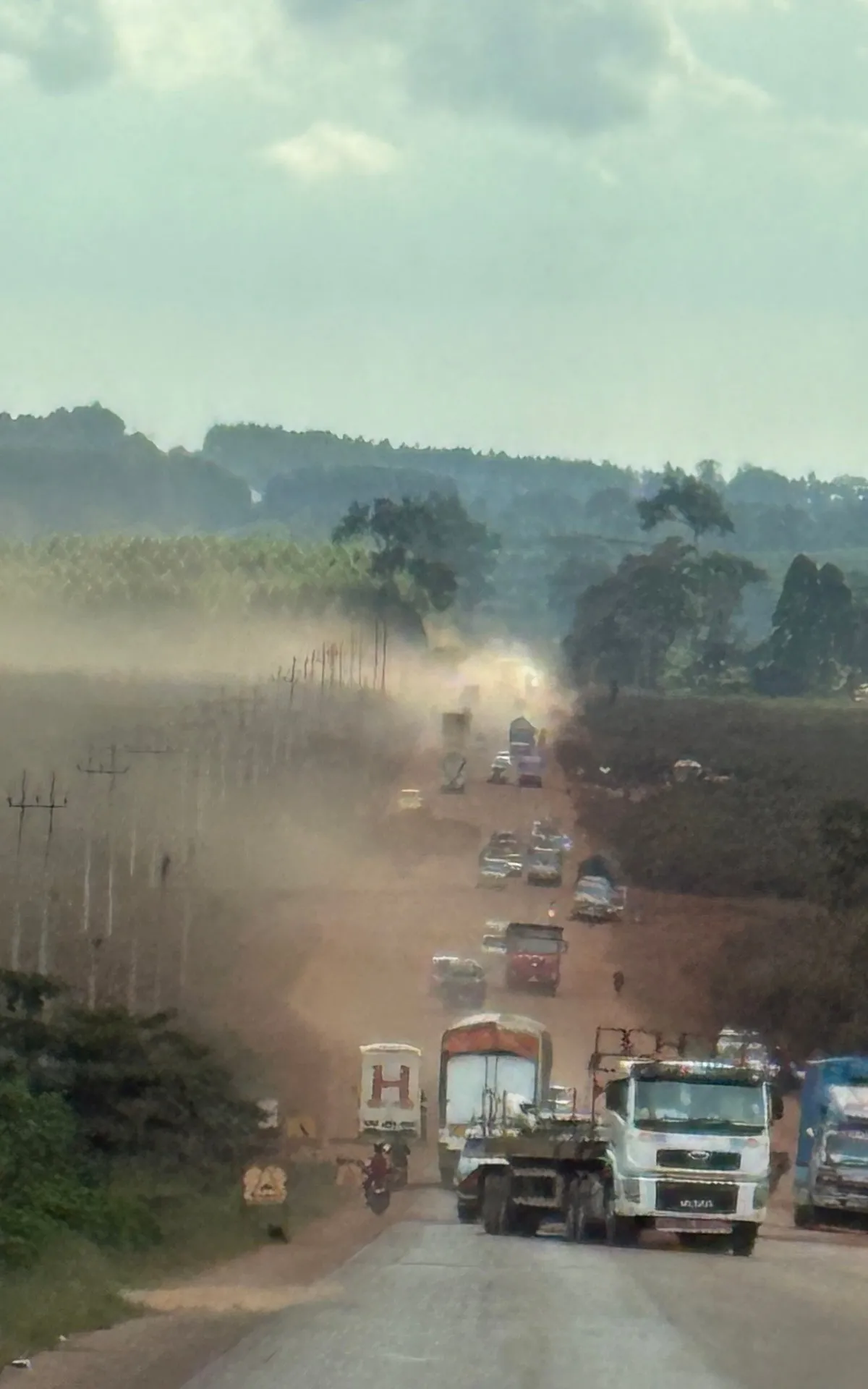 Staubige Straße auf dem Highway nach Bwindi — der Weg zur Gemeinschaft