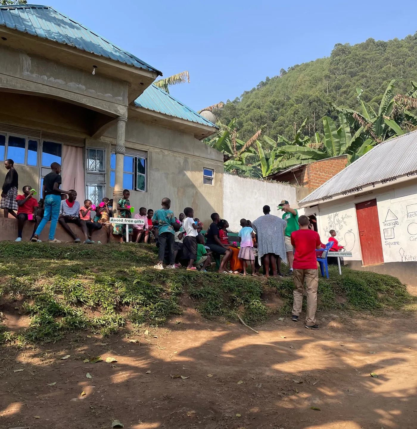 Children in the courtyard of the Buhoma orphanage — meals, homework, and play all happen in this shared outdoor space. Photo: Mark Suer