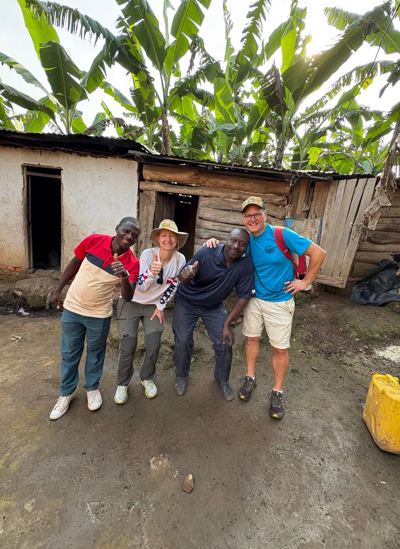 Four people present the first batch of chicks purchased for the Buhoma orphanage from a local chicken farmer, June 2026. Photo: Mark Suer